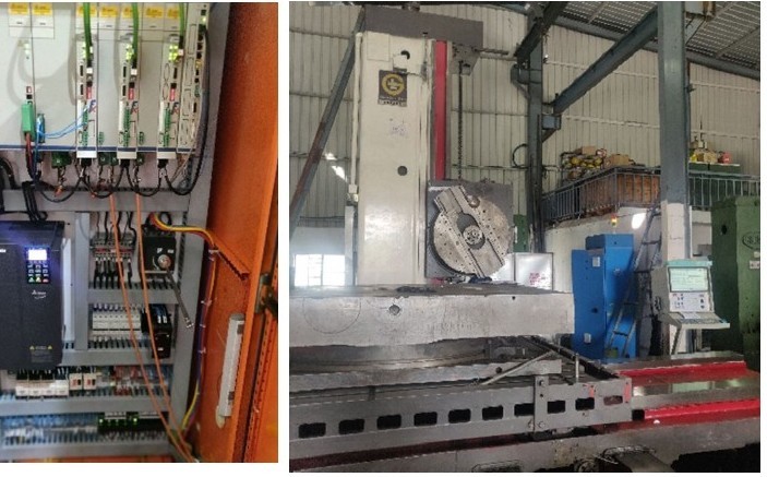 Large CNC machine on a shop floor, with its control cabinet open beside it